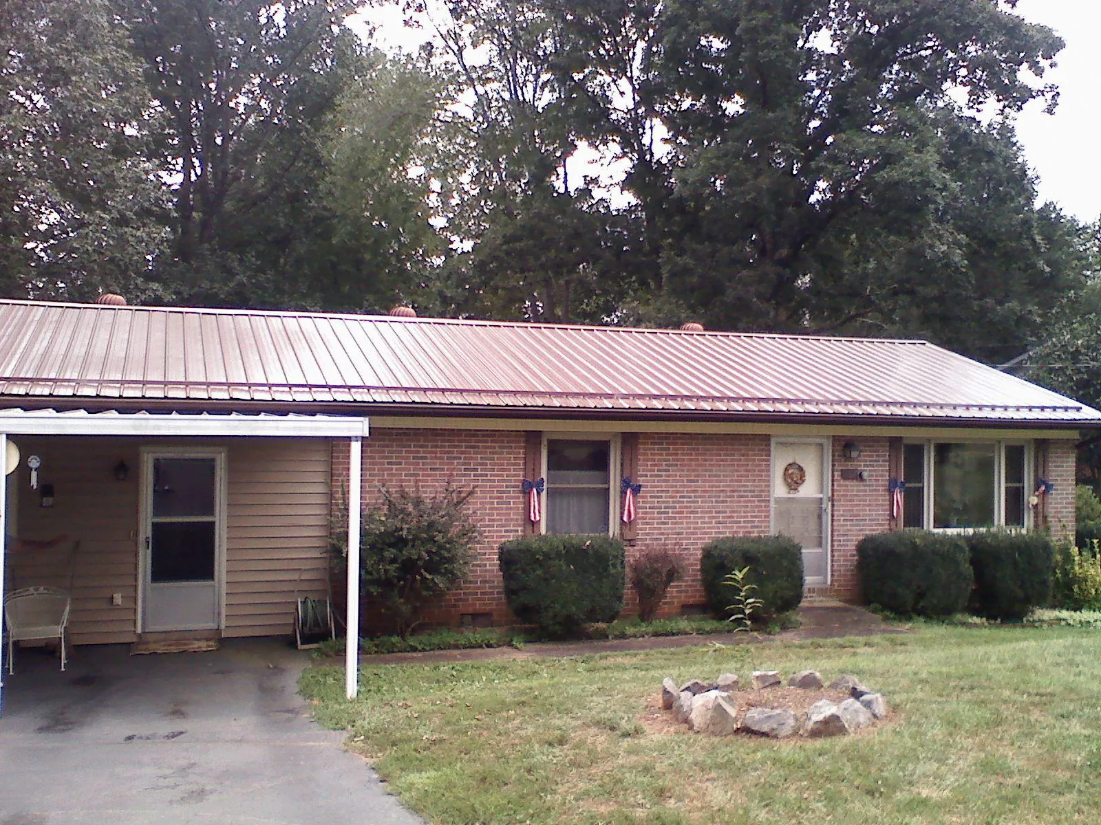 Bronze metal roof and carport on a brick ranch home — Roof Repair work by our crew in Lena