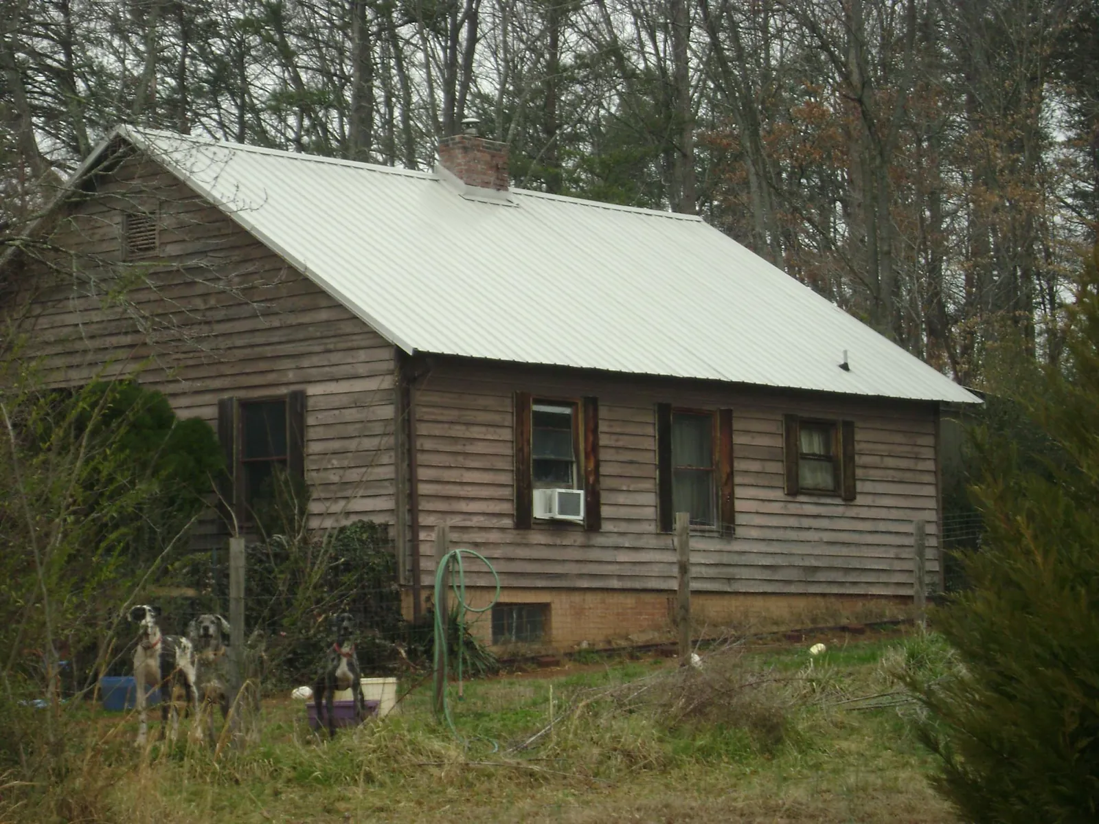 White metal roof on an old wood sided farmhouse, from a Metal Roof Installation job in Lena